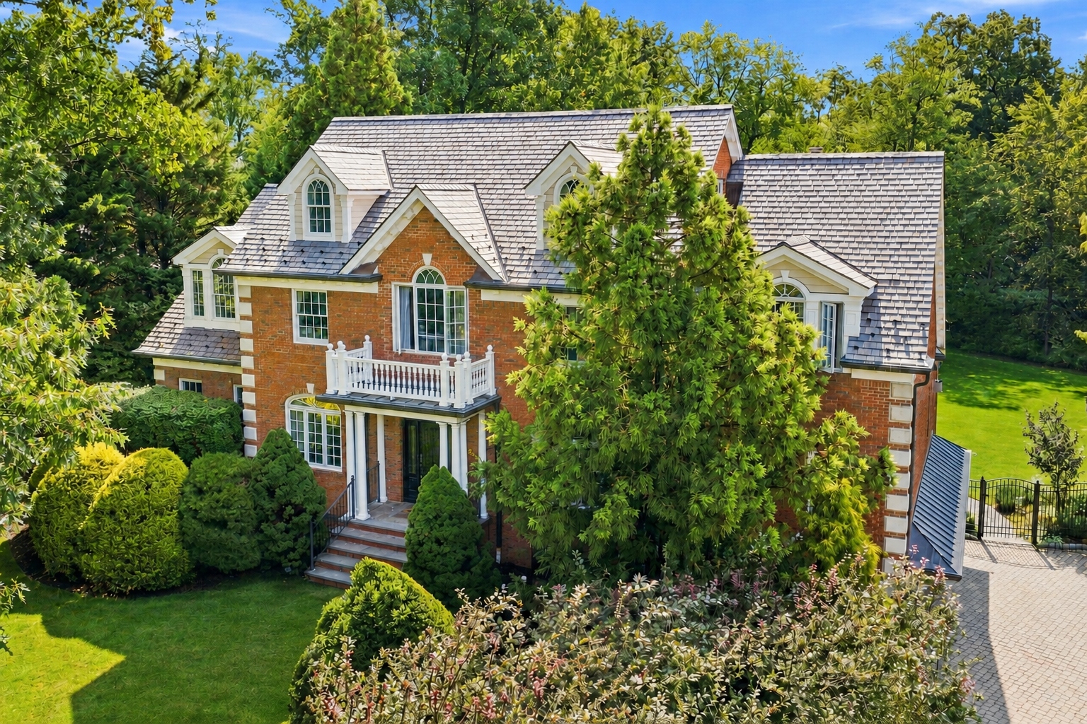 285 Hartshorn Drive, Short Hills, NJ — all-brick Center Hall Colonial front facade with a balustraded balcony and columned entry